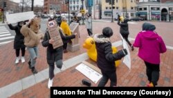 Pro-Thai democracy protesters dance around the monument during the demonstration at King Bhumibol Adulyadej Square in Cambridge, MA Nov 22, 2020.