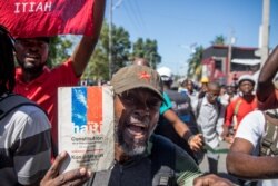 Demonstrators march to protest the government of President Jovenel Moise, in Port-au-Prince, Feb. 10, 2021.