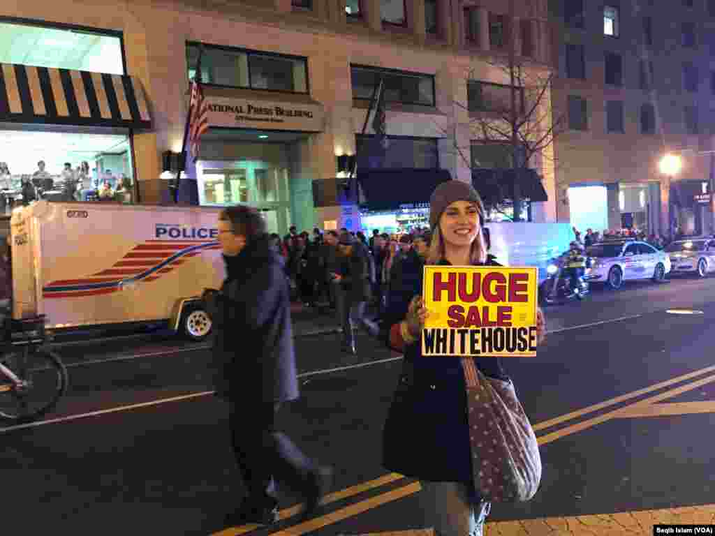 Outside the National Press Club in Washington, D.C., a young woman holds an anti-Trump protest sign, Jan. 19, 2017. 