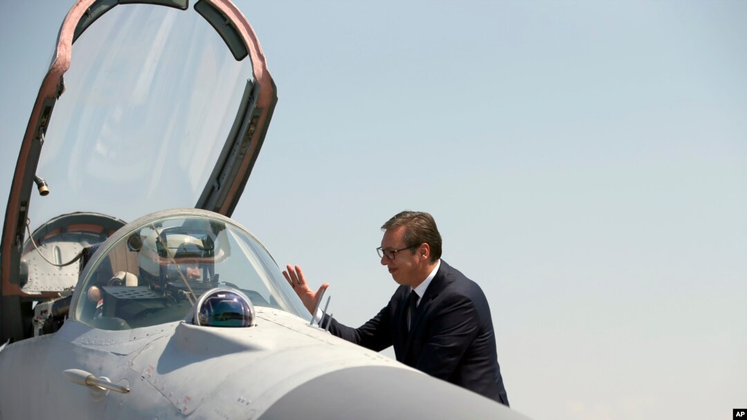 Serbian President Aleksandar Vucic speaks with a pilot of MiG-29 jet fighter on the tarmac at Batajnica, military airport near Belgrade, Serbia, Aug. 21, 2018. 