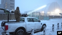 A Ukrainian serviceman stands on a vehicle with an anti-aircraft gun after a drone attack at the former Chernobyl nuclear power plant, Ukraine, Feb. 14, 2025.