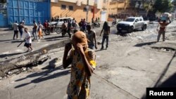 People walk on a street after civilians and members of the National Police clashed with gangs, in Port-au-Prince, Haiti, Feb. 23, 2025.