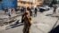 People walk on a street after civilians and members of the National Police clashed with gangs, in Port-au-Prince, Haiti, Feb. 23, 2025.
