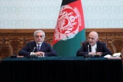 FILE - Afghanistan's President Ashraf Ghani and his rival-turned-coalition-partner Abdullah Abdullah attend a ceremony to sign a political agreement in Kabul, Afghanistan, May 17, 2020.