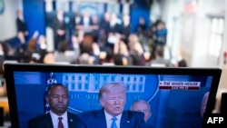 FILE - A TV screen shows President Donald Trump speaking on the coronavirus outbreak, at the White House, March 21, 2020, in Washington. A lawsuit in Wisconsin is blocking a local TV station from airing an ad blasting Trump's response to the crisis. 