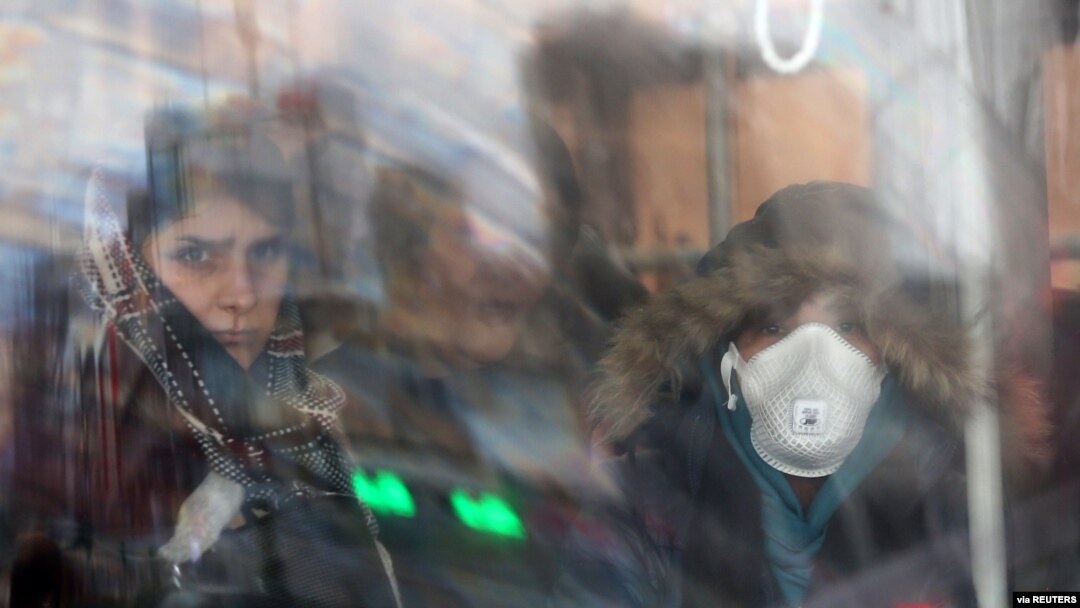An Iranian woman wears a protective mask to prevent contracting coronavirus, as she sits in the bus in Tehran, Iran, Feb. 25, 2020.
