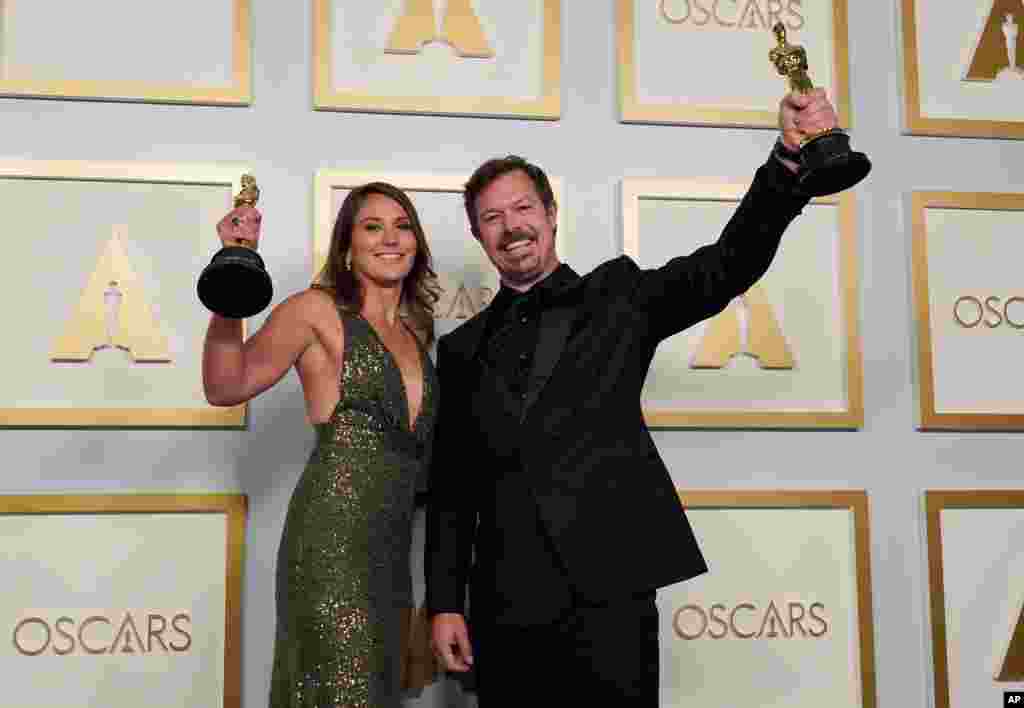 Pippa Ehrlich, left, and James Reed pose in the press room with the award for best documentary feature for &quot;My Octopus Teacher&quot; at the Oscars on Sunday, April 25, 2021, at Union Station in Los Angeles. (AP Photo/Chris Pizzello, Pool)