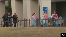 FILE - This photo taken from video provided by WEAR-TV shows emergency responders following a shooting incident at Naval Air Station Pensacola, in Pensacola, Florida, Dec. 6, 2019. 