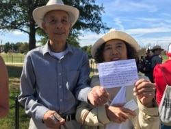 A Chinese couple sought tickets to the reopening of the Washington Monument in Washington, Sept. 19, 2019. They said their ancestors donated a stone on the 10th floor of the monument. (P. Widakuswara/VOA)
