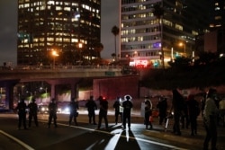 Protesters confront police officers while blocking the 110 Freeway during a protest over the death of George Floyd on May 29, 2020, in Los Angeles.