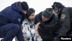 Astronot Michael Hopkins dari NASA ditolong keluar dari kapsul Soyuz setelah mendarat di Zhezkazgan, Kazakhstan (11/3). 