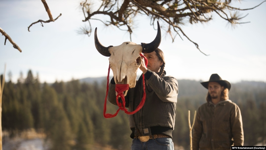 Mo (actor Mo Brings Plenty) raises a bison skull in a vision quest ceremony for Kayce Dutton (Luke Grimes) in Season 4, Episode 9 of Paramount+ "Yellowstone."