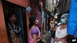 A health worker screens people for symptoms of COVID-19 in Dharavi, one of Asia's biggest slums, in Mumbai, India, Sept. 4, 2020.