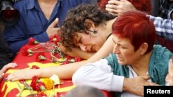 Family members of Korkmaz Tedik, a victim of Saturday's bomb blasts, mourn over his coffin during a funeral ceremony in Ankara, Turkey, Oct. 11, 2015.