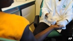 Un agent de santé bénévole prélève du sang sur un patient pour un test de dépistage du VIH-SIDA, à Noe, une ville en Côte d'Ivoire près de la frontière du Ghana, 18 juin 2008.