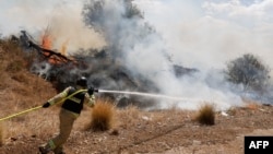 Firefighters douse flames in a field after a drone launched from southern Lebanon fell near Senir Kibbutz in the Upper Galilee in northern Israel, Sept. 16, 2024.