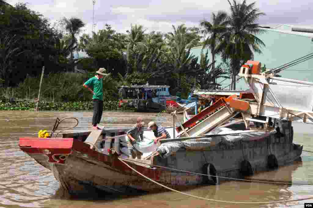 Workers unload rice from a boat in Tien Giang, Vietnam, September 14, 2012. (D. Schearf/VOA)