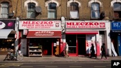 FILE - People walk past the Polish Mleczko delicatessen and restaurant in London, April 5, 2016. Following right-wing election gains, Eurosceptics in Austria and Poland are keeping a close eye on Britain’s June 23rd referendum to stay or quit the European