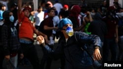 Opposition demonstrators throw stones at police during a protest against Venezuela's President Nicolas Maduro's government in Caracas, Feb. 12, 2014. 