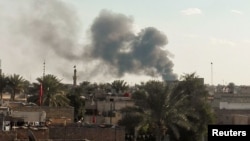 Smoke rises from the site of a suicide car bomb attack at a used cars dealers parking in Hayy al-Shurta, neighborhood in southern Baghdad, Iraq, Feb, 16, 2017.