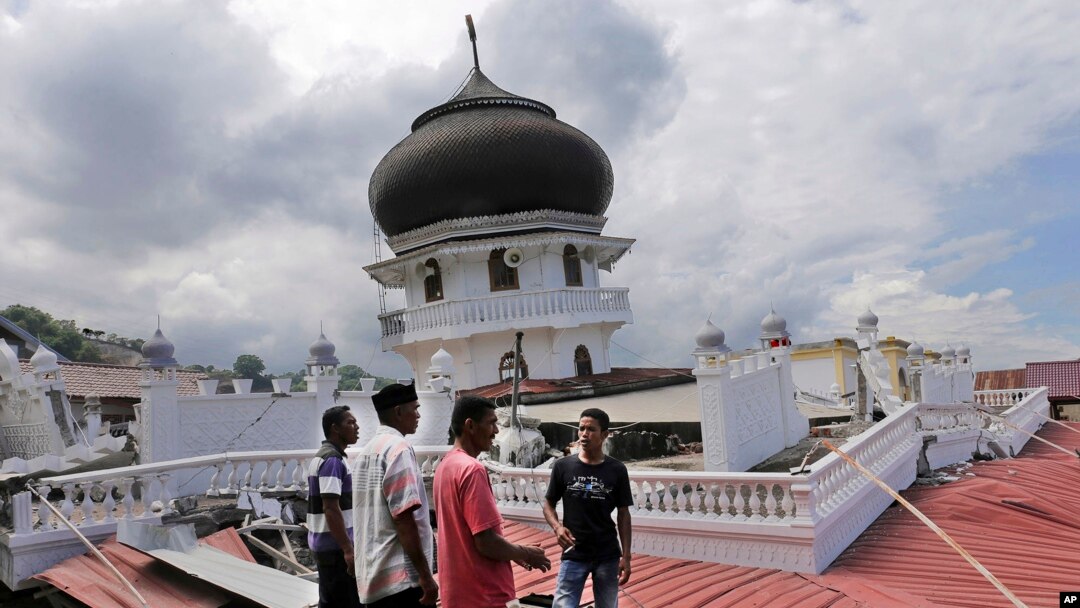 Warga memeriksa sebuah masjid yang amblas karena gempa di Pidie Jaya, Aceh (7/12). (AP/Heri Juanda)