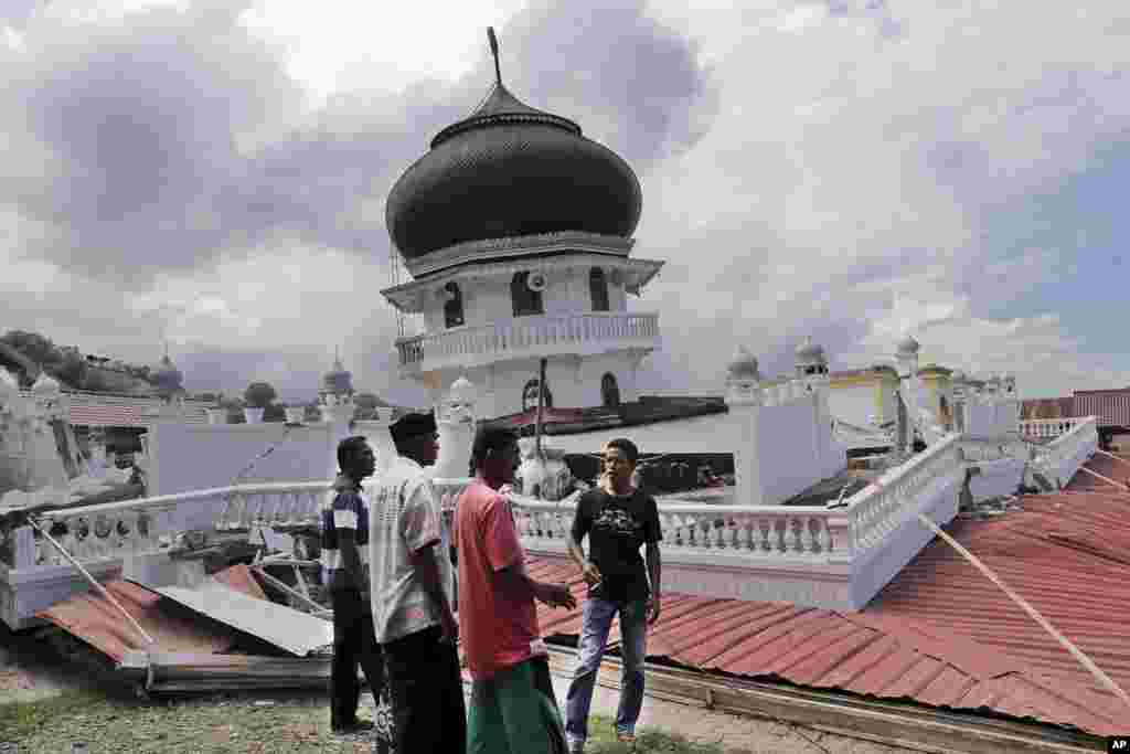 Warga memeriksa sebuah masjid yang rusak akibat gempa di Pidie Jaya, Aceh (7/12). (AP/Heri Juanda)