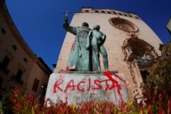 A graffiti reading "racist" is seen on a statue of Fray Junipero Serra in Palma de Mallorca, Spain, June 22, 2020.