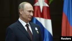 Russia's President Vladimir Putin looks on after Cuba's President Raul Castro decorated him with the Order of Jose Marti during a ceremony at Havana's Revolution Palace, July 11, 2014. 