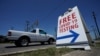 FILE - A pick-up truck passes a sign for free COVID-19 testing, in San Antonio, Texas, Aug. 14, 2020.