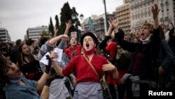 People dance and sing during a demonstration to mark International Women&#39;s Day in front of the parliament building in Athens, Greece.
