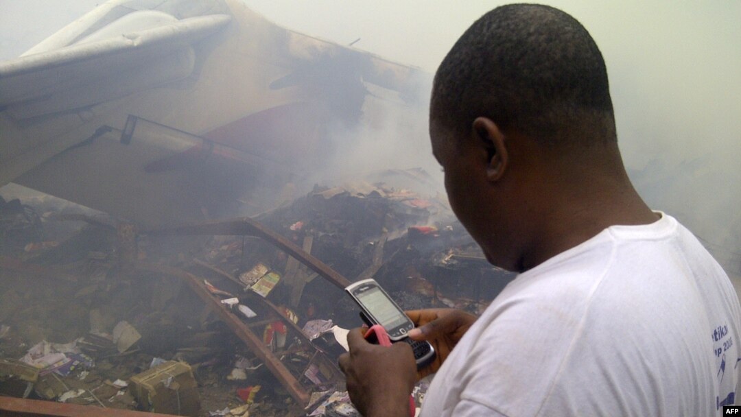 A man using his cell phone in a neighborhood just north of Murtala Muhammed International Airport, in Lagos, Nigeria, June 3, 2012.