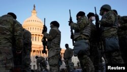 Miembros de la Guardia Nacional reciben armas antes de que los demócratas comiencen a debatir un artículo de juicio político contra el presidente de Estados Unidos, Donald Trump, en el Capitolio de Estados Unidos, en Washington, el 13 de enero de 2021. 