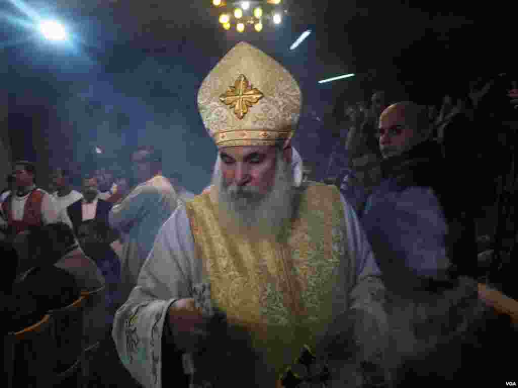 A priest fumigates an area of the church during Christmas Eve in Cairo, Egypt, Jan. 6, 2017. (H. Elrasam/VOA)
