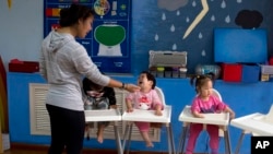 FILE - Children attend classes at a foster home of the New Hope Foundation on the outskirts of Beijing, Oct. 11, 2017.