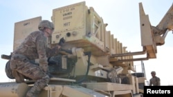 Specialist Tevin Howe and Specialist Eduardo Martinez take part in training on a U.S. Army Patriot surface-to-air missile launcher at Al Dhafra Air Base, United Arab Emirates, Jan. 12, 2019.