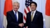 U.S. Defense Secretary Chuck Hagel (L) and Japan's Prime Minister Shinzo Abe shake hands before their meeting at the latter's former official residence in Tokyo, April 5, 2014. 