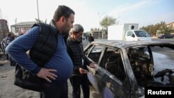 Um homem olha para um carro queimado, que foi atingido por um bombardeio durante o conflito militar na região separatista de Nagorno-Karabakh, na cidade de Barda, Azerbaijão, 28 de outubro de 2020