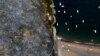 A burnt mountain over a beach in Agia Anna village on Evia island, about 148 kilometers (92 miles) north of Athens, Greece, Aug. 10, 2021.