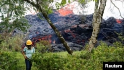 FILE - Lava erupts from a fissure east of the Leilani Estates subdivision during ongoing eruptions of the Kilauea volcano, May 12, 2018.