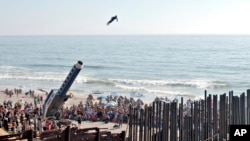 ARCHIVO - David “The Human Cannonball” Smith Jr. sobrevuela la valla fronteriza entre Estados Unidos y México desde el área de Playas de Tijuana en Tijuana hasta San Diego, durante un festival de arte el 27 de agosto de 2005.