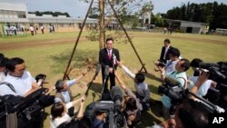 Noraha Mayor Yukiei Matsumoto, center, speaks to journalists as the town reopens four-and-a-half years after the tsunami and nuclear disaster, in Naraha, Fukushima, Japan, Sept. 5, 2015.