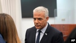 Tokoh oposisi Israel, Yair Lapid, tiba di pengadilan distrik Yerusalem untuk bersaksi dalam persidangan kasus korupsi yang membelit Perdana Menteri Benjamin Netanyahum pada 12 Juni 2023. (Foto: AP/Ohad Zwigenberg)