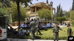 Syrian soldiers and police members secure the area near the U.S. Embassy in Damascus, July 12, 2011.