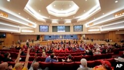 Aktivis Imigrasi dan imigran mengangkat tangan mereka dalam perjanjian dengan salah satu pembicara mereka dalam sidang dengar keterangan di gedung Miami-Dade County, di pusat kota Miami, Jumat, 17 Februari, 2017. (AP Photo / Alan Diaz)