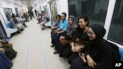 People ride on a Mass Rapid Transit (MRT) during a trial run in Jakarta, Indonesia, Feb. 21, 2019. The 10-mile system running south from Jakarta's downtown is the first phase of a development that will plant a cross-shaped network of stations across the city.