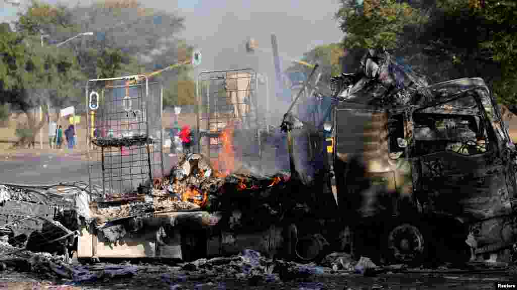 Un habitant passe devant un camion incendié près de la route où les manifestants sont passés à Atteridgeville, à l&#39;ouest de Pretoria, Afrique du Sud, le 21 juin 2016.