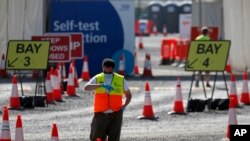 Seorang petugas menunggu peserta tes Covid-19 di fasilitas lantatur (drive thru) stadion Twickenham, London, yang sepi pengunjung, 17 September 2020. (AP Photo/Frank Augstein) 