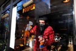 Argentine chef Leo Lanussol, owner of the Proper restaurant, cleans a window at the Gran Dabbang restaurant, where it's owner Mariano Ramon and him made a partnership in order to continue working…