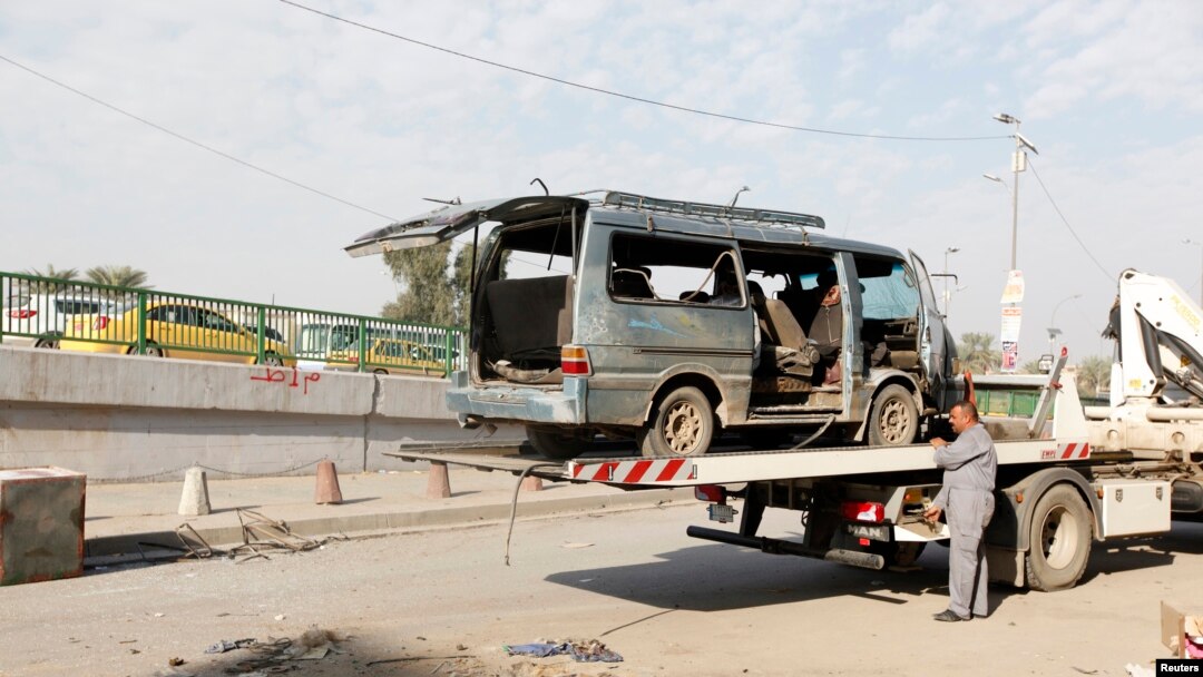 Seorang pekerja bersiap memindahkan rongsokan kendaraan di tempat kejadian serangan bom di Baghdad, Iraq, 8 Desember 2013.