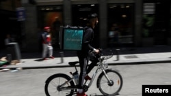 Un cycliste livreur de nourriture porte un sac Deliveroo à Madrid, en Espagne.
